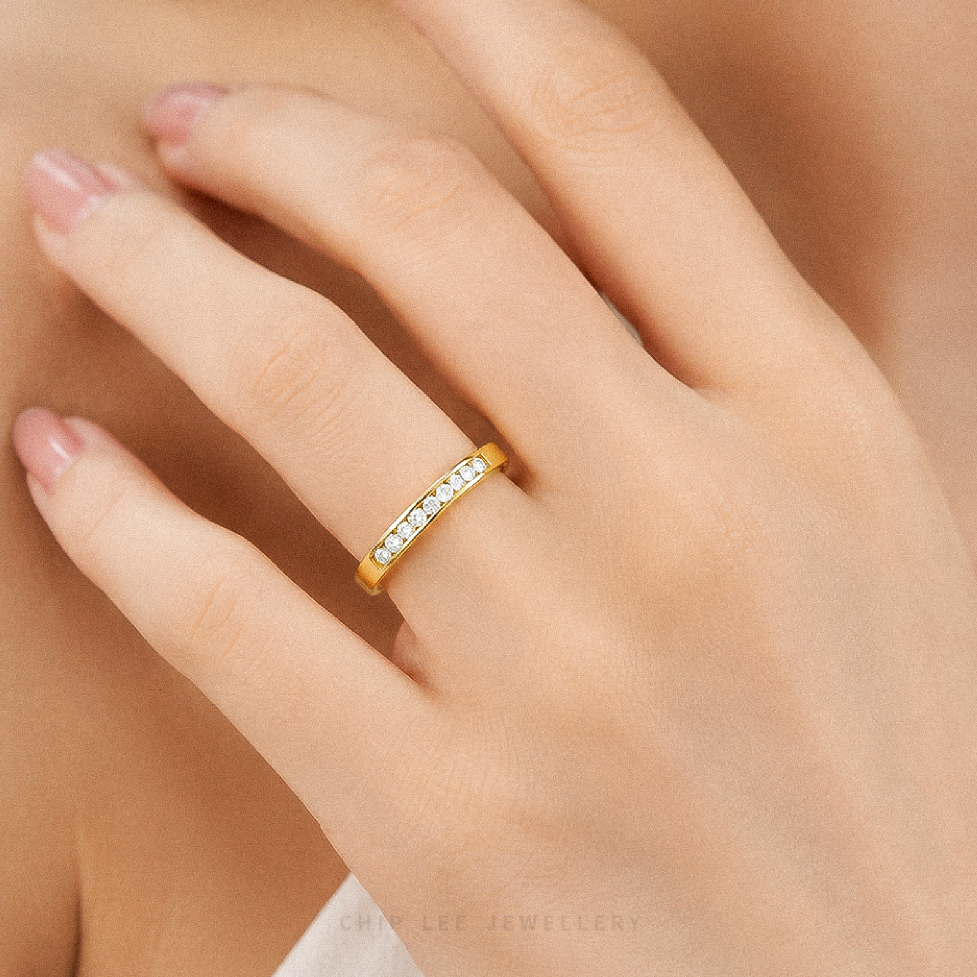 Gold half eternity ring featuring brilliant round-cut cubic zirconia stones in a polished minimalist setting.