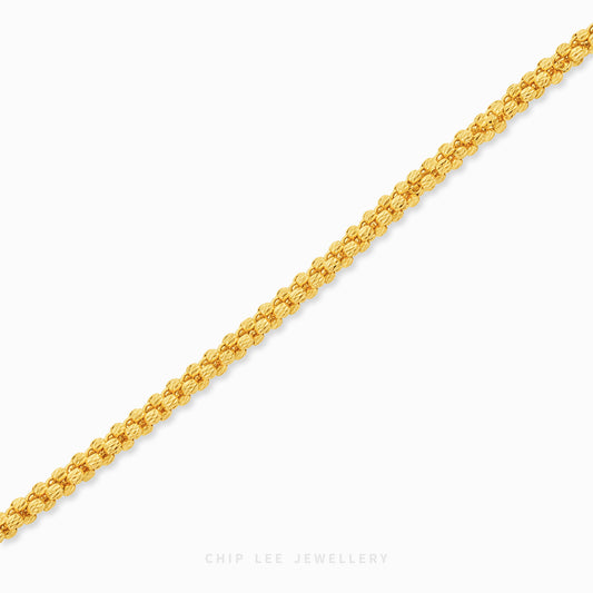 Dorezza gold bracelet featuring intricate, closely interlocking nugget-shaped links that create a richly textured and dimensional gold chain design.