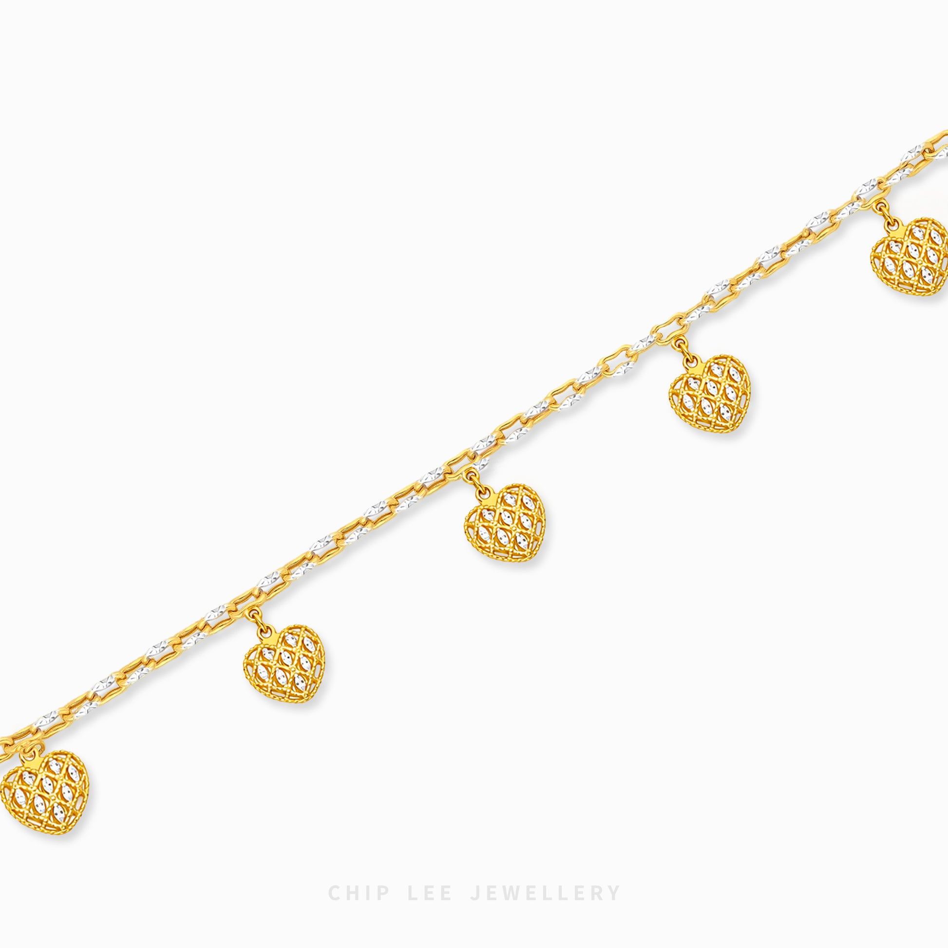 A gold chain bracelet with five dangling heart charms, each featuring an intricate openwork pattern. The chain is alternating with small clear stones.