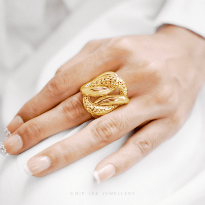 Gold ring on a hand with a white background