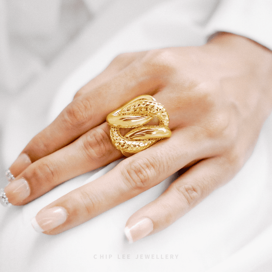 Gold ring on a hand with a white background