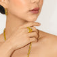 A close-up lifestyle shot of a model wearing a chunky, textured gold ring on her finger, matching gold hoop earring, and gold chain necklace. The brand name 'CHIP LEE JEWELLERY' is faintly watermarked at the bottom.
