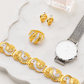 Gold and silver jewelry set including bracelet, ring, and watch on a white surface.