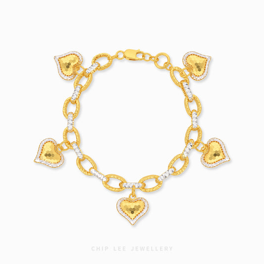 Gold bracelet with heart-shaped charms on a white background