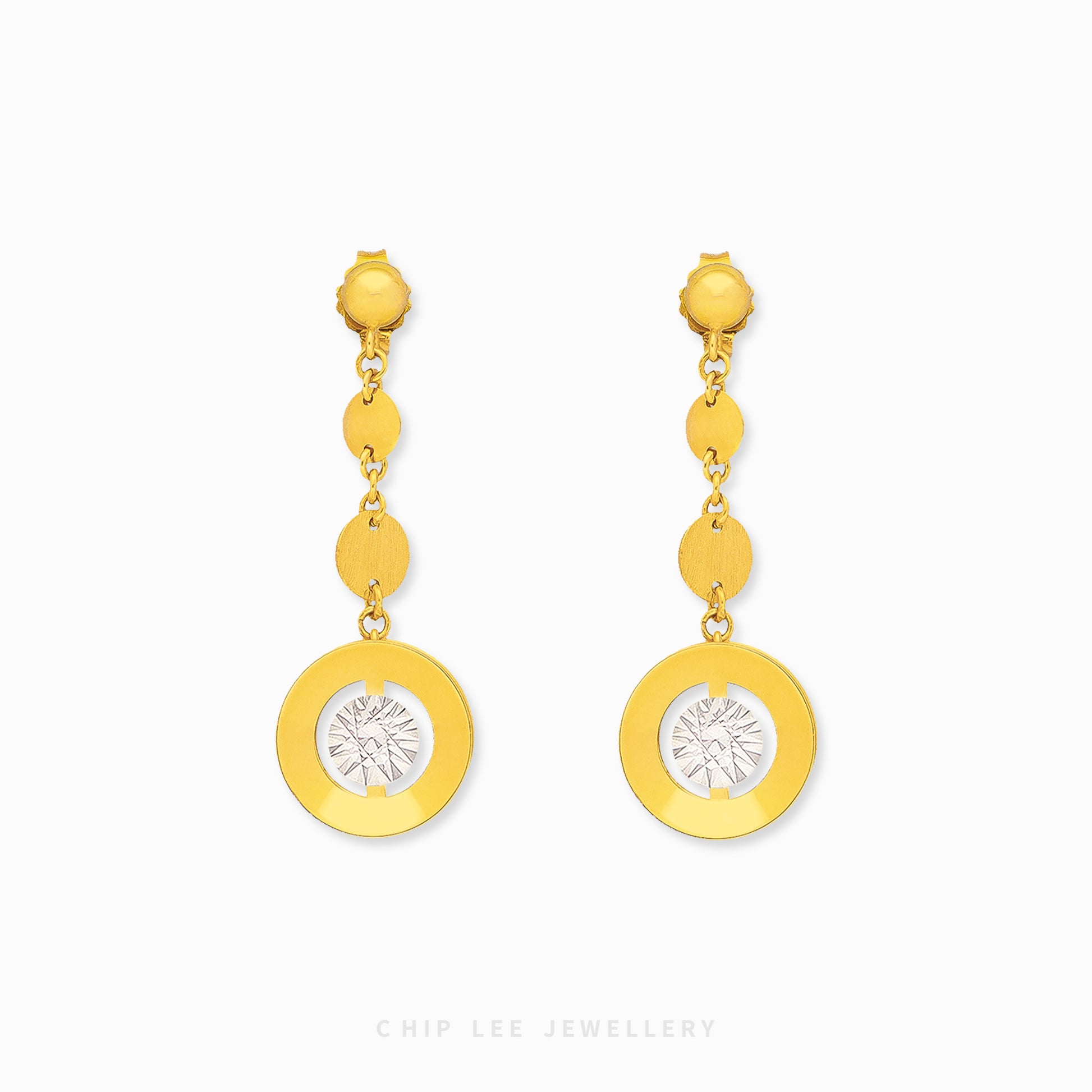 Gold earrings with circular designs on a white background