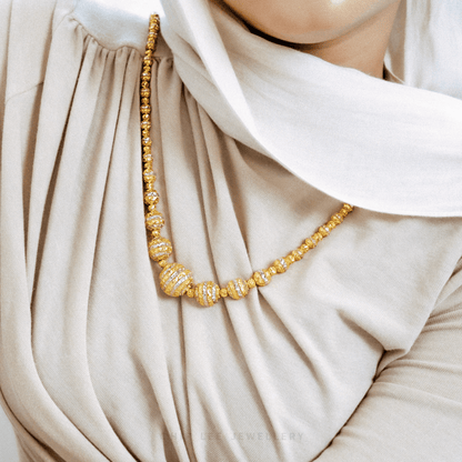 Gold necklace on a beige hijab