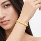 A close-up lifestyle shot of a model wearing a yellow gold bangle bracelet with pavé-set clear stones on the ends. The brand name 'CHIP LEE JEWELLERY' is subtly watermarked at the bottom.