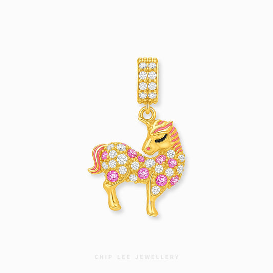 A gold unicorn charm pendant from Chip Lee Jewellery, embellished with pink and clear rhinestones on a light gray background.