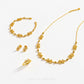 Gold jewelry set by Chip Lee Jewellery featuring a necklace, bracelet, earrings, and ring, all decorated with small flower motifs and polished bead details, arranged on a clean white background.
