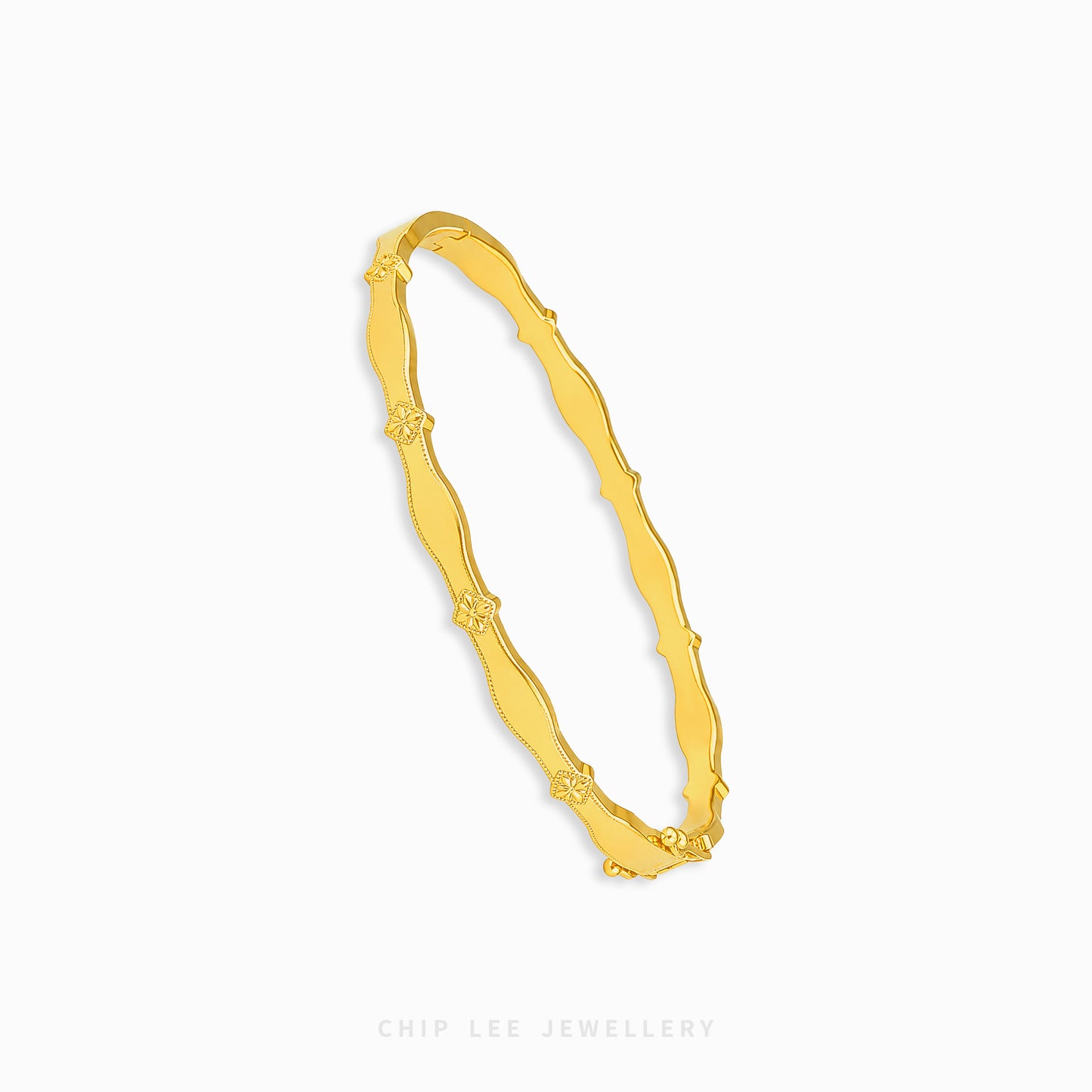 A gold bangle bracelet with a wavy, textured design and small floral details spaced along the band, shown on a plain white background with the brand name 'CHIP LEE JEWELLERY' printed at the bottom.