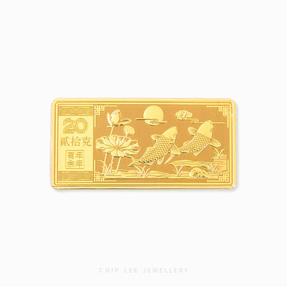 A 999 pure gold bar with an embossed design featuring fishes and flowers with Chinese characters. Hallmarked in Singapore for certified purity and authenticity.