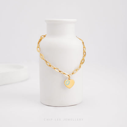 Dainty heart charm bracelet adorned with turquoise enamel detail, certified and hallmarked by Singapore Assay Office for purity and authenticity.