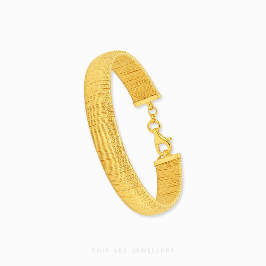 A textured yellow gold bangle bracelet with a lobster clasp, displayed on a clean white background with the brand name 'CHIP LEE JEWELLERY' printed at the bottom.