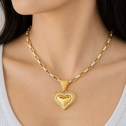 Gold heart-shaped necklace on a person with 'Chip Lee Jewellery' branding.