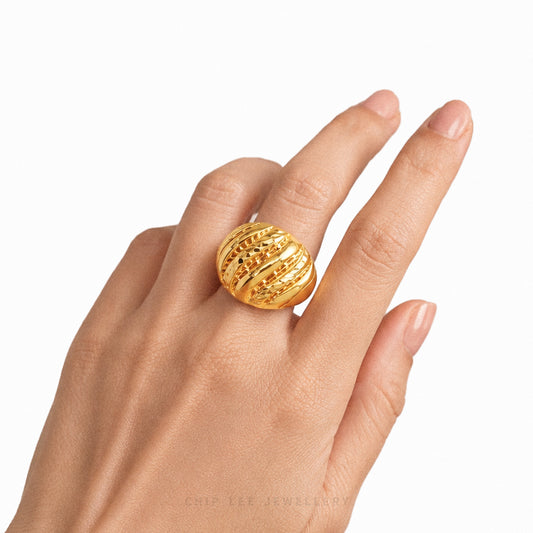 Gold ring on a hand with a white background