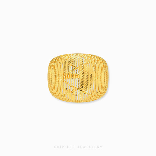 A chunky gold bangle bracelet with a textured, vertically ribbed openwork pattern, shown on a clean white background with a subtle drop shadow.