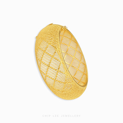 A gold-toned open bangle bracelet with a geometric diamond-patterned wire mesh design, shown on a clean white background with a Chip Lee Jewellery watermark at the bottom.