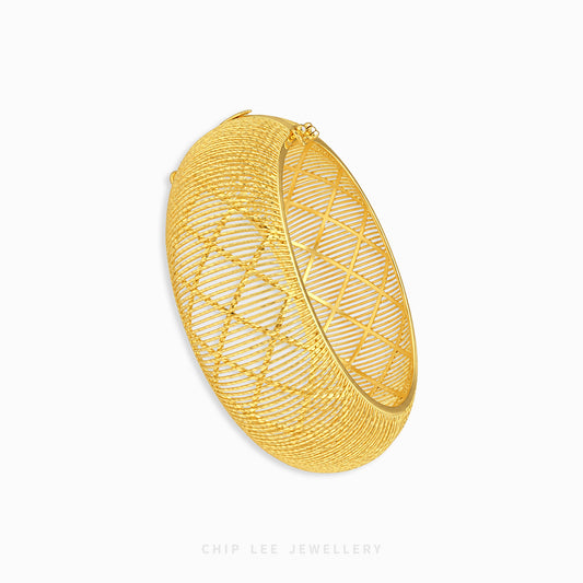 A gold-toned open bangle bracelet with a geometric diamond-patterned wire mesh design, shown on a clean white background with a Chip Lee Jewellery watermark at the bottom.
