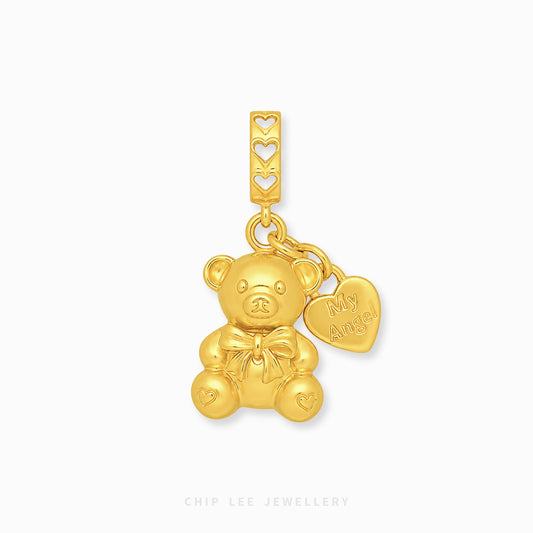 A gold teddy bear charm pendant with a heart-shaped tag engraved with 'My Angel', displayed on a clean white background.