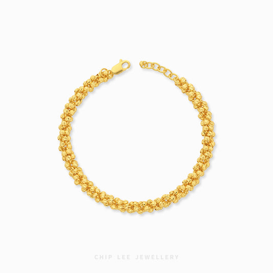 Odette Bracelet featuring intricate, closely interlocking nugget-shaped links that create a richly textured and dimensional gold chain design.