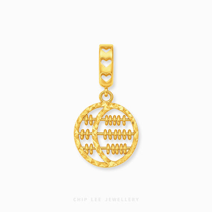 A gold pendant charm featuring a circular design with horizontal lines resembling a traditional abacus, suspended from a bail decorated with three heart cutouts, shown on a light gray background.