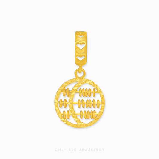 A gold charm in the shape of a circle with a crescent and abacus design.