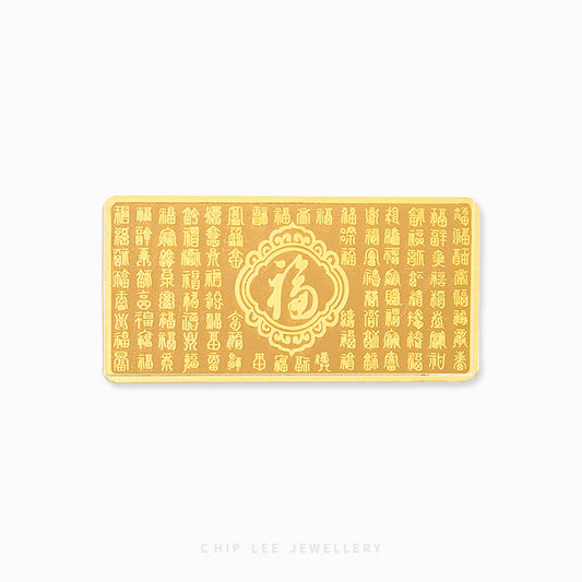 A 999 pure gold bar with embossed Chinese characters and an auspicious symbol design in the center. Hallmarked in Singapore for certified purity and authenticity.