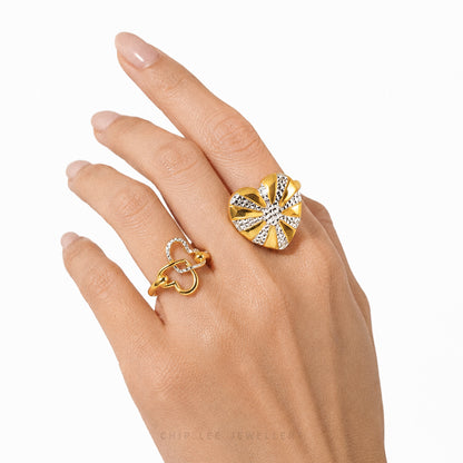 Hand wearing two gold rings on a white background
