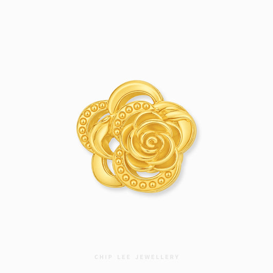 A gold flower-shaped charm with layered petals and beaded detailing, centered on a plain white background with 'CHIP LEE JEWELLERY' printed faintly at the bottom.