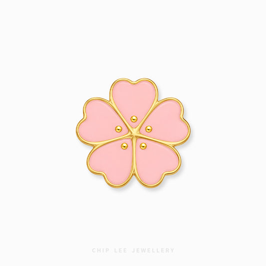 A pink cherry blossom flower-shaped charm with gold metal borders and three small gold dots in the center, shown on a plain white background with Chip Lee Jewellery branding at the bottom.