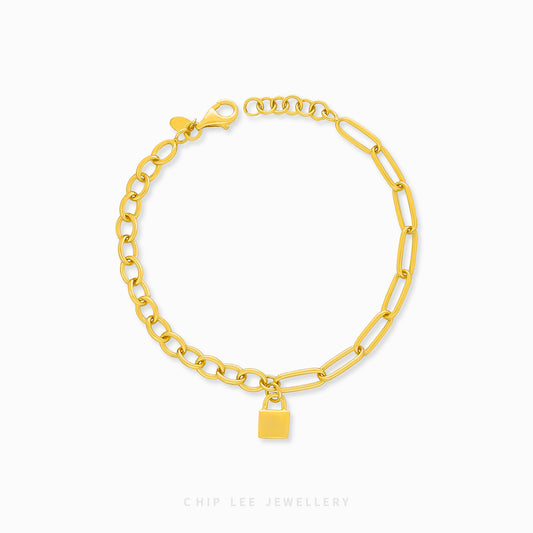 Gold chain bracelet with a lock charm on a white background