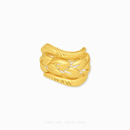 A gold-toned multi-band ring with a textured, braided cable design, shown on a plain white background with a brand watermark at the bottom.