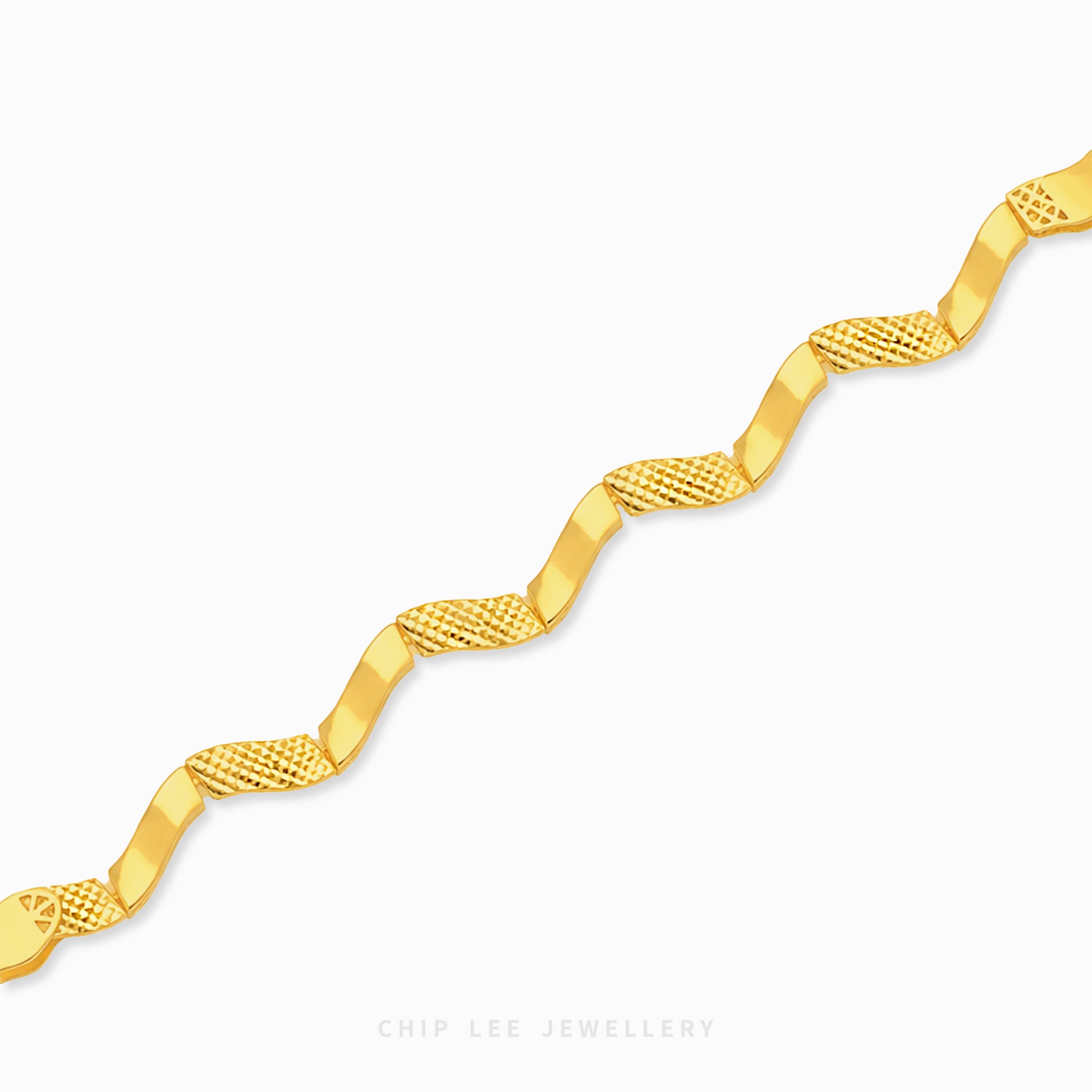 A gold chain bracelet with a wavy, zig-zag design featuring alternating smooth and textured diamond-patterned links, shown on a light gray background with a Chip Lee Jewellery watermark.